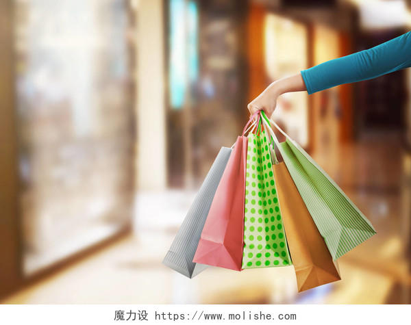 购物中心人手执彩色购物袋摄影图